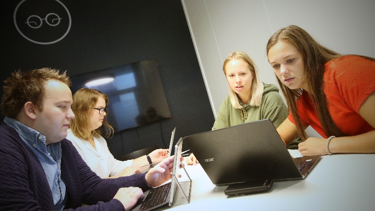 Andreas Ek Pedersen, Mari Telise Nilsen, Ida Groven og Linn Cecilie Solberg sitter inne på et av campus Drammens grupperom og diskuterer innholdet i den digitale kunnskapsreisen. foto.