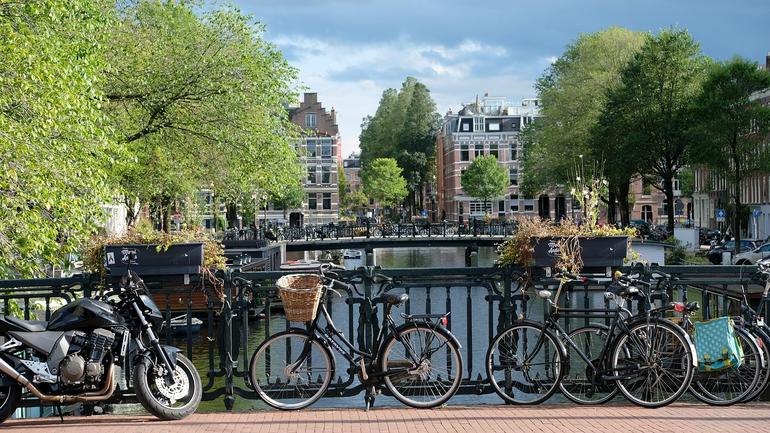 Fire sykler står på en bro i Amsterdam