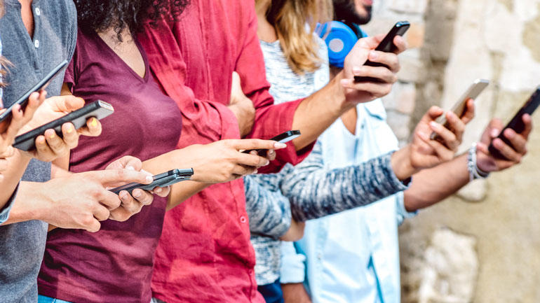 anonymiserte ungdommer med mobiltelefoner i hendene.Foto