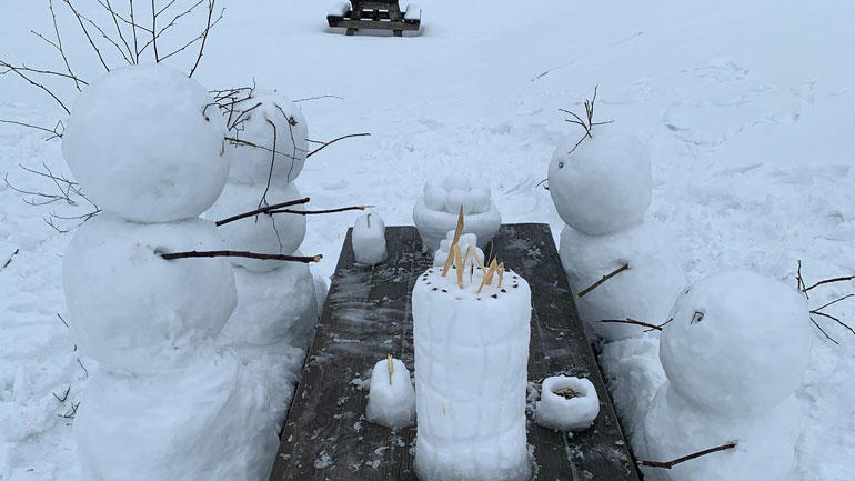 Bilde av fire snømenn som sitter på en benk