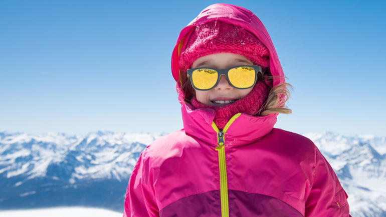 vinterkledt jente med solbriller. fjellandskap i bakgrunnen 