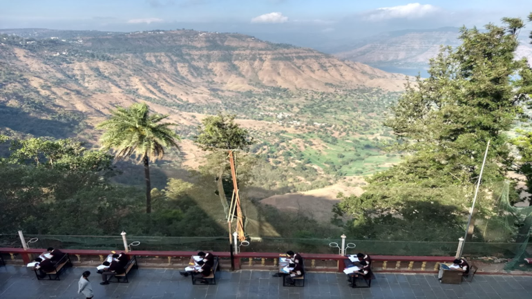 indiske elever har skoleeksamen utendørs med et fantastisk naturlandskap som bakgrunn. Foto