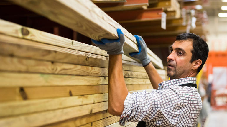 Mannlig innvandrer i arbeid i byggvarehus. foto