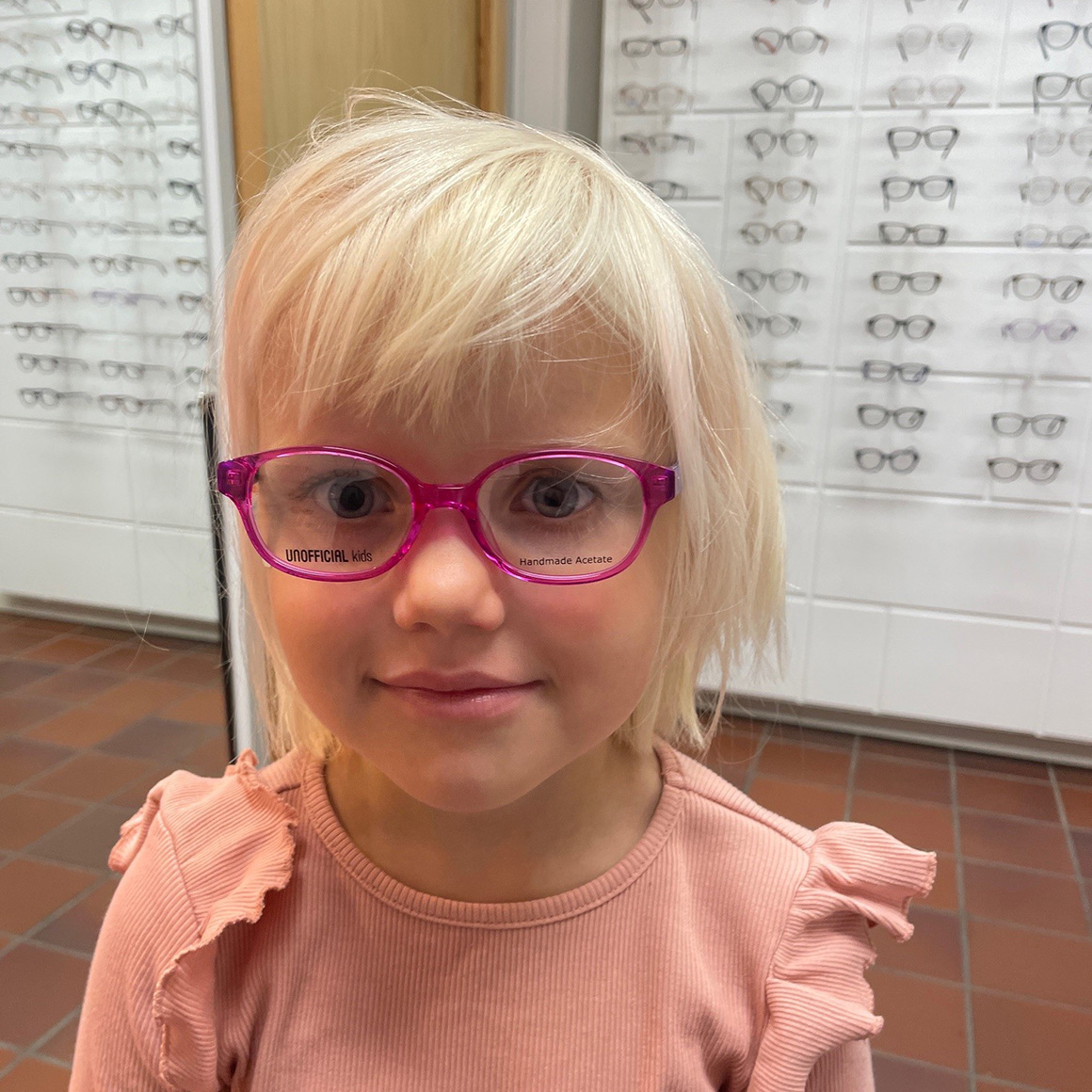 Jente prøver briller i butikk